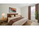 A staged bedroom featuring a modern aesthetic, with a houseplant near the window at 15120 Cavanshire Trl, Charlotte, NC 28278