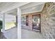 Welcoming covered front porch with stone facade, entry door with glass and white doorframe at 15120 Cavanshire Trl, Charlotte, NC 28278