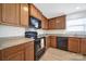 Kitchen featuring dark appliances, wood cabinets, hardwood floors, and granite countertops at 15120 Cavanshire Trl, Charlotte, NC 28278