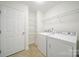 Well-lit laundry room with washer, dryer and wire shelving at 15120 Cavanshire Trl, Charlotte, NC 28278