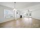 Open-concept living space with hardwood floors, a fireplace, and large windows for ample natural light at 15120 Cavanshire Trl, Charlotte, NC 28278
