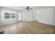 An open living space with hardwood floors, a fan and access to outdoor porch and backyard at 15120 Cavanshire Trl, Charlotte, NC 28278