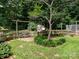 Fenced backyard with a garden, potted plants, wooden structure, and a large shade tree at 170 Eagle Dr, Salisbury, NC 28144
