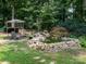 Beautiful backyard featuring a charming pond, seating area, playground, and lush greenery at 170 Eagle Dr, Salisbury, NC 28144