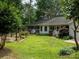 Backyard view with a screened porch, beautiful landscaping, and outdoor swing at 170 Eagle Dr, Salisbury, NC 28144