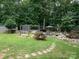 Backyard with an outdoor entertainment area, wooden swing, and luscious greenery at 170 Eagle Dr, Salisbury, NC 28144