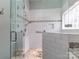 Modern tiled shower with glass doors and a pebble floor offers a luxurious bathing experience at 17709 Sedona Way, Cornelius, NC 28031