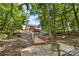 Back yard featuring wooden walking path, firepit and seating nestled among mature trees at 18568 Mainsail Ct, Lancaster, SC 29720
