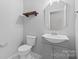 A modern bathroom with stylish mirror, gray vanity, and white toilet at 18568 Mainsail Ct, Lancaster, SC 29720