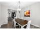 Dining room with modern light fixture, hardwood floors and view of the kitchen at 18568 Mainsail Ct, Lancaster, SC 29720