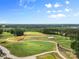 Scenic view of a lush green golf course with manicured fairways, mature trees, and blue sky at 18568 Mainsail Ct, Lancaster, SC 29720