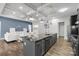 Open-concept kitchen and living area featuring a large island with a sink, sleek cabinetry, and hardwood flooring at 18568 Mainsail Ct, Lancaster, SC 29720