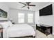 Well-lit bedroom with ceiling fan, TV and two windows at 2726 Tranquil Oak Pl, Charlotte, NC 28206