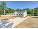 Inviting single-story home with white siding, a covered porch, long driveway, and partially fenced backyard at 286 Old Pinckney Rd, York, SC 29745