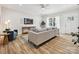 Bright living room featuring a gray sofa, wood floors, mounted TV, and lots of natural light at 286 Old Pinckney Rd, York, SC 29745