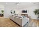 Open living room with a gray sofa, wood floors, mounted TV, and a round decorative mirror at 286 Old Pinckney Rd, York, SC 29745