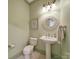 Charming powder room with a pedestal sink, patterned wallpaper, and decorative mirror at 2909 Julian Glen Cir, Waxhaw, NC 28173