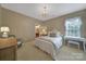 Neutral bedroom with a connecting bathroom and vanity, plush carpet, and bright window with blinds at 2909 Julian Glen Cir, Waxhaw, NC 28173