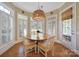 Cozy dining area with a wooden table, chandelier, and natural light streaming through the windows at 2909 Julian Glen Cir, Waxhaw, NC 28173