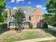 Beautiful two-story brick home with manicured landscaping and a covered front porch and seating at 2909 Julian Glen Cir, Waxhaw, NC 28173