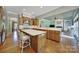Open-concept kitchen with a large island, bar stools, and seamless flow into the living area at 2909 Julian Glen Cir, Waxhaw, NC 28173