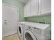 Functional laundry room with white cabinets and modern washer and dryer units at 2909 Julian Glen Cir, Waxhaw, NC 28173