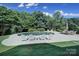 Inviting backyard pool area with ample seating and a tranquil waterfall feature surrounded by mature trees at 2909 Julian Glen Cir, Waxhaw, NC 28173