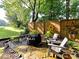 Backyard retreat featuring a stone patio, wooden bench, fire pit, and decorative fence, creating a serene outdoor space at 3401 Cresta Ct, Charlotte, NC 28269