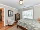 Bedroom featuring hardwood floors, an upholstered chair, and a unique display cabinet at 3401 Cresta Ct, Charlotte, NC 28269