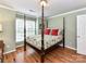 This charming bedroom has a four-poster bed, hardwood floors, and bright natural light at 3401 Cresta Ct, Charlotte, NC 28269
