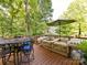 Outdoor deck featuring a hot tub, dining table with chairs, and umbrella, creating a perfect relaxation spot at 3401 Cresta Ct, Charlotte, NC 28269