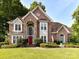 Stunning brick home with a red door, mature landscaping and a manicured lawn creates exceptional curb appeal at 3401 Cresta Ct, Charlotte, NC 28269