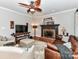 Cozy living room with a fireplace, ceiling fan, and comfortable leather sofa at 3401 Cresta Ct, Charlotte, NC 28269