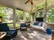 Inviting screened porch with a swing, comfortable seating, ceiling fan, and picturesque views of lush greenery at 3401 Cresta Ct, Charlotte, NC 28269