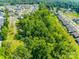 Lush green trees and landscaping in this aerial view of the neighborhood with well maintained lawns and sidewalks at 3849 Carl Parmer Dr, Harrisburg, NC 28075