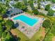 Aerial view of a community pool surrounded by lush landscaping, lounge chairs, and a covered patio at 3849 Carl Parmer Dr, Harrisburg, NC 28075