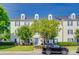 Three-story condo complex with white siding, blue shutters, green trees and lawn at 3849 Carl Parmer Dr, Harrisburg, NC 28075