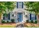 Charming entryway with a blue door, flanked by windows with blue shutters, and neat landscaping at 3849 Carl Parmer Dr, Harrisburg, NC 28075