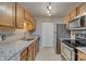 Well-lit kitchen featuring wood cabinets, granite countertops, stainless steel appliances, and a tiled backsplash at 3849 Carl Parmer Dr, Harrisburg, NC 28075