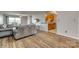 Open-concept living room flowing into a kitchen with wood cabinets, featuring wood floors and a comfortable sofa at 3849 Carl Parmer Dr, Harrisburg, NC 28075