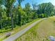 Scenic walking path winding through a grassy landscape with mature trees and a park bench at 3849 Carl Parmer Dr, Harrisburg, NC 28075