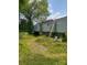 Exterior view featuring aluminum siding, overgrown weeds, and a ladder at 3913 Stough Sw Rd, Concord, NC 28027