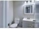 Half bathroom featuring a white toilet, vanity, and sink with a decorative mirror and light fixture at 3919 Briarhill Dr, Charlotte, NC 28215