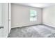 Bedroom features neutral colored walls, gray carpeting, and a large window that provides natural light at 3919 Briarhill Dr, Charlotte, NC 28215