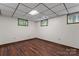 Basement bedroom with hardwood flooring, drop ceiling, and multiple windows at 3943 Peggy Ln, Mint Hill, NC 28227
