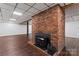 Finished basement with brick fireplace, hardwood floors, and drop ceiling at 3943 Peggy Ln, Mint Hill, NC 28227