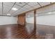 Spacious finished basement with brick feature wall and wood support beams at 3943 Peggy Ln, Mint Hill, NC 28227