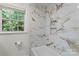 Elegant bathroom features luxurious marble tile and natural light from the window at 3943 Peggy Ln, Mint Hill, NC 28227