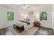 Bright bedroom showcasing a comfortable bed, neutral decor, and natural light from surrounding windows at 3943 Peggy Ln, Mint Hill, NC 28227