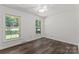Bright, minimalist bedroom with hardwood floors and plenty of natural light from large windows at 3943 Peggy Ln, Mint Hill, NC 28227